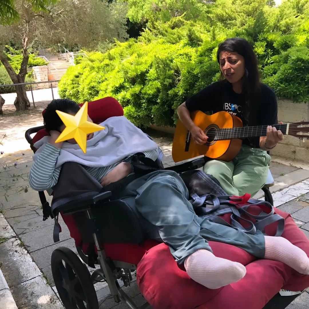 Voluntária tocando violão em atividade social